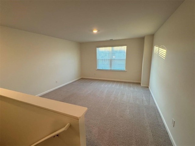 spare room featuring baseboards and carpet flooring