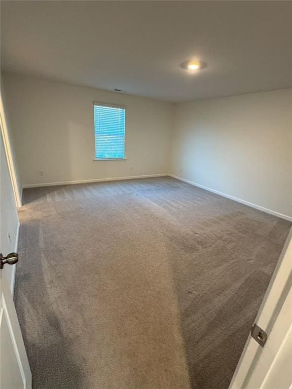 carpeted empty room with baseboards