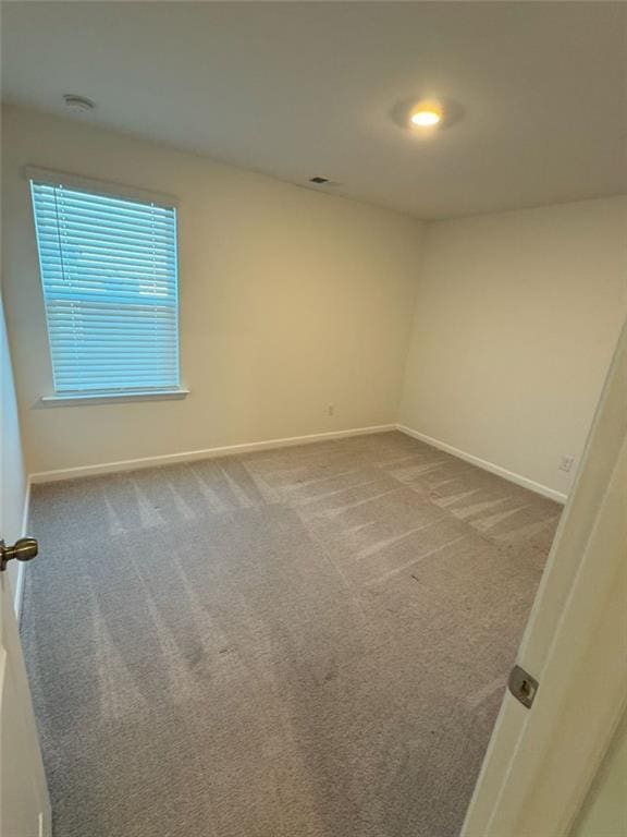 spare room with carpet and baseboards