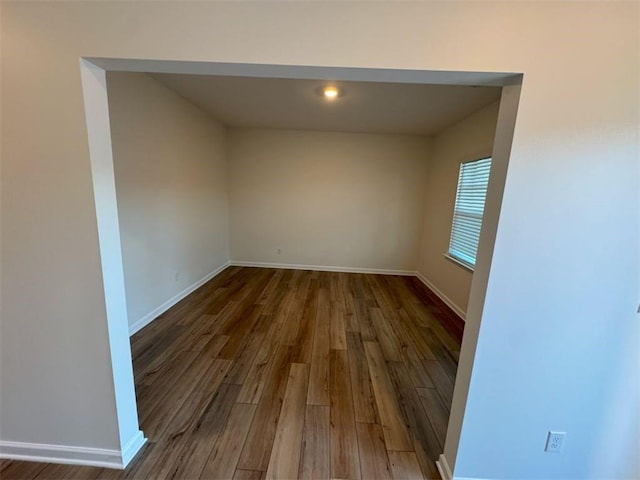 unfurnished room with baseboards and wood finished floors