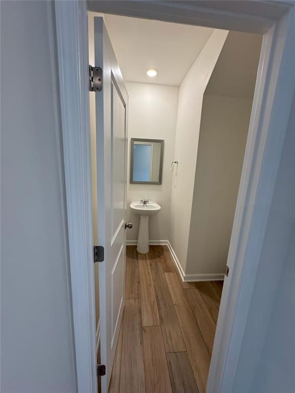 bathroom with a sink, baseboards, and wood finished floors