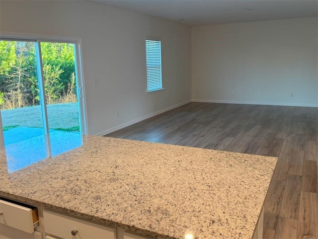 empty room with baseboards and wood finished floors