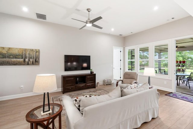 living room featuring ceiling fan and light hardwood / wood-style floors