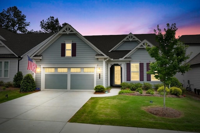 craftsman-style house featuring a garage and a lawn