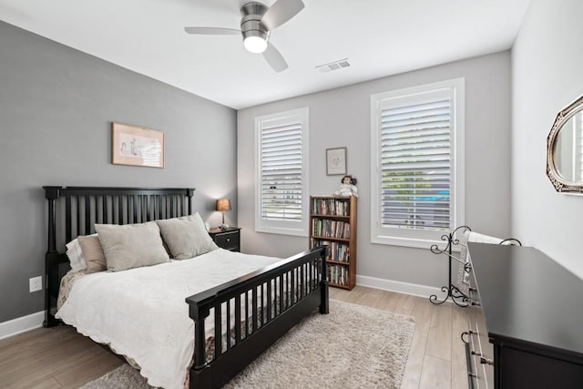 bedroom featuring light wood-type flooring, multiple windows, and ceiling fan