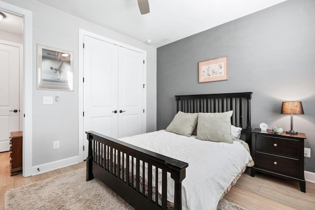 bedroom with a closet, light hardwood / wood-style floors, and ceiling fan