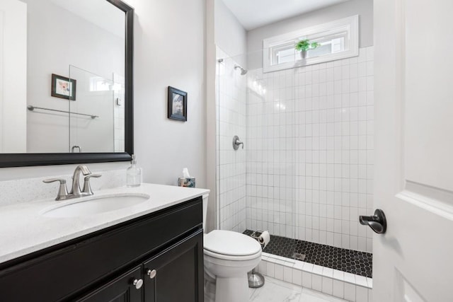 bathroom featuring vanity, toilet, and tiled shower