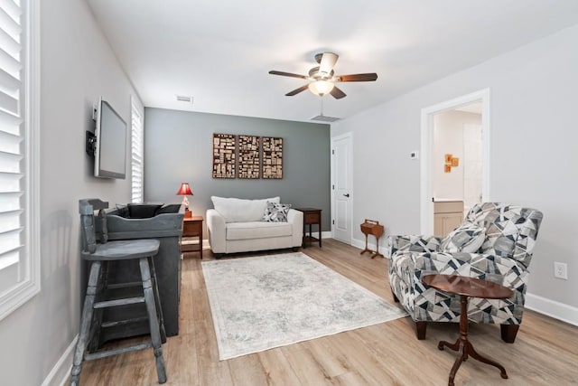 living room featuring light wood-type flooring and ceiling fan