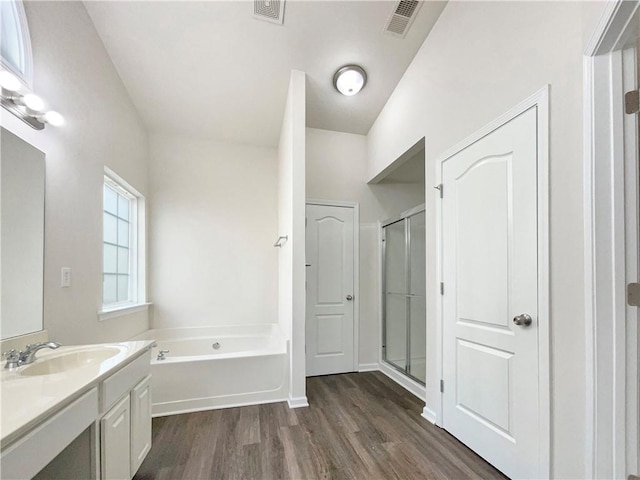 bathroom with plus walk in shower, vanity, and hardwood / wood-style flooring