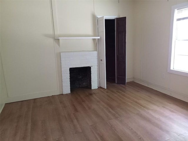 2205 Buchanan Hwy, Cedartown, GA 30125 - unfurnished living room with wood finished floors, a brick fireplace, and baseboards