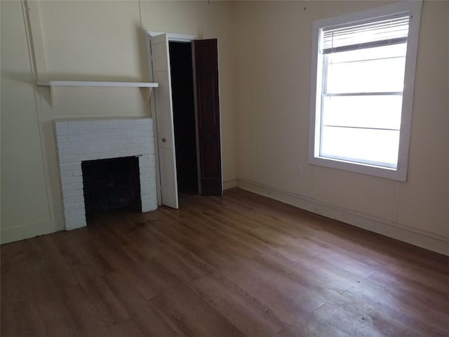 2205 Buchanan Hwy, Cedartown, GA 30125 - unfurnished living room featuring wood finished floors, plenty of natural light, and a brick fireplace