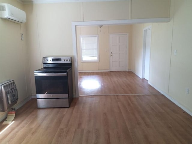 2205 Buchanan Hwy, Cedartown, GA 30125 - kitchen with stainless steel electric range oven, a wall mounted air conditioner, heating unit, light wood-style flooring, and baseboards