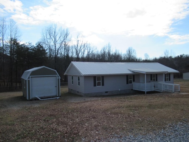 ranch-style home with an outbuilding, a porch, and a garage