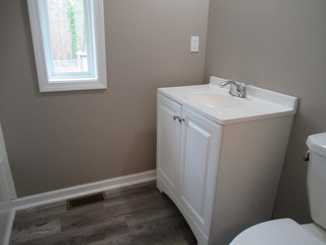 bathroom with vanity, toilet, and wood-type flooring