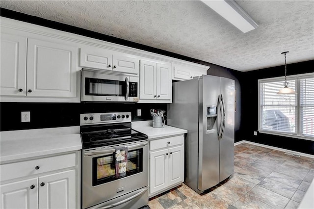 kitchen featuring appliances with stainless steel finishes, light countertops, and white cabinetry