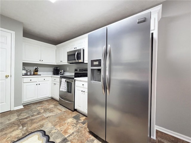 4184 Wyndham Park Way, Buford, GA 30519 - kitchen featuring stainless steel appliances, stone finish flooring, white cabinetry, and baseboards