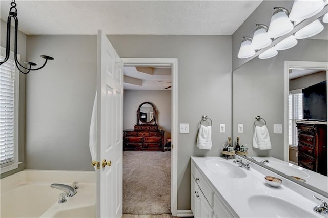 full bathroom featuring a textured ceiling, double vanity, and a sink