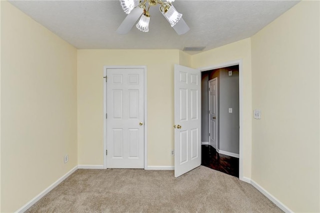 unfurnished bedroom with carpet floors, visible vents, ceiling fan, a textured ceiling, and baseboards