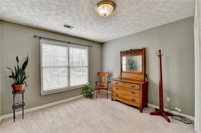 sitting room featuring carpet, visible vents, a textured ceiling, and baseboards