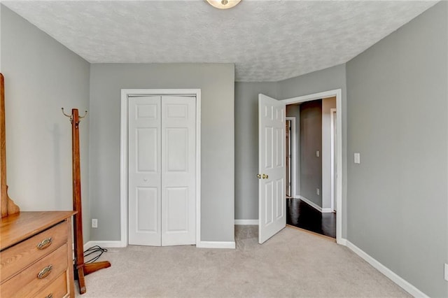 bedroom featuring baseboards, a closet, and light colored carpet