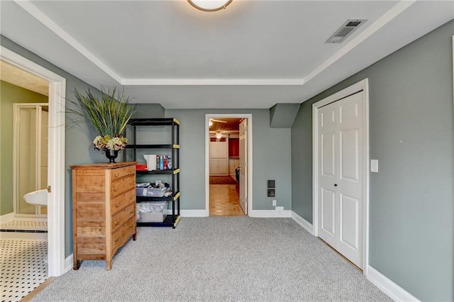 carpeted bedroom featuring connected bathroom, visible vents, and baseboards