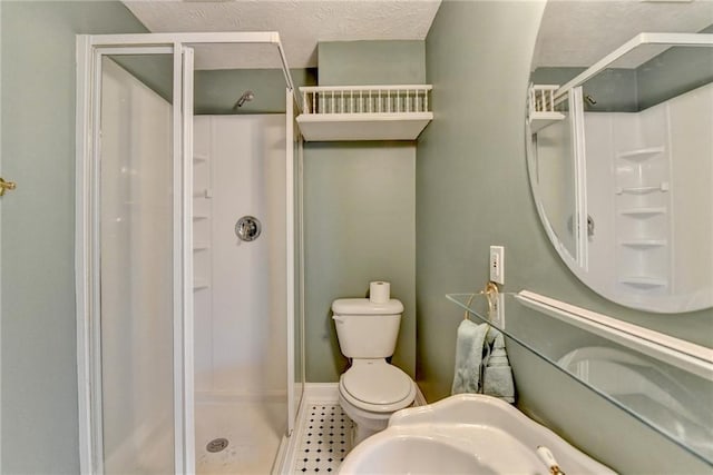 bathroom featuring a stall shower, a textured ceiling, and toilet