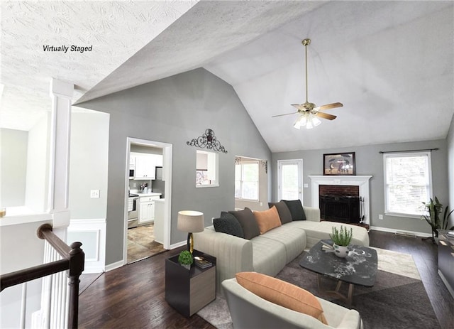 4184 Wyndham Park Way, Buford, GA 30519 - living area with lofted ceiling, healthy amount of natural light, dark wood-type flooring, and a fireplace with raised hearth