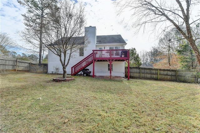 back of property with a fenced backyard, stairs, a deck, and a yard