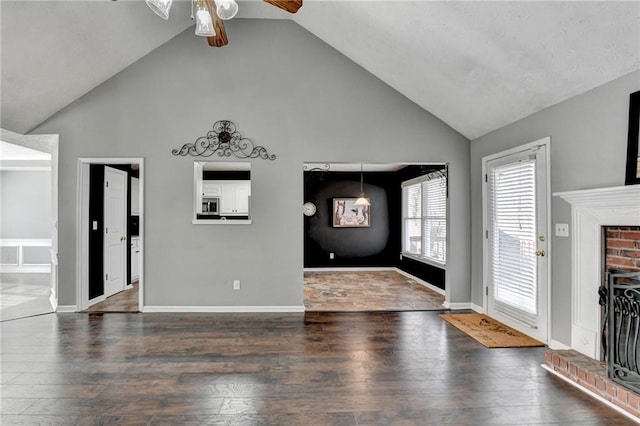 interior space featuring high vaulted ceiling, wood-type flooring, a fireplace, and baseboards