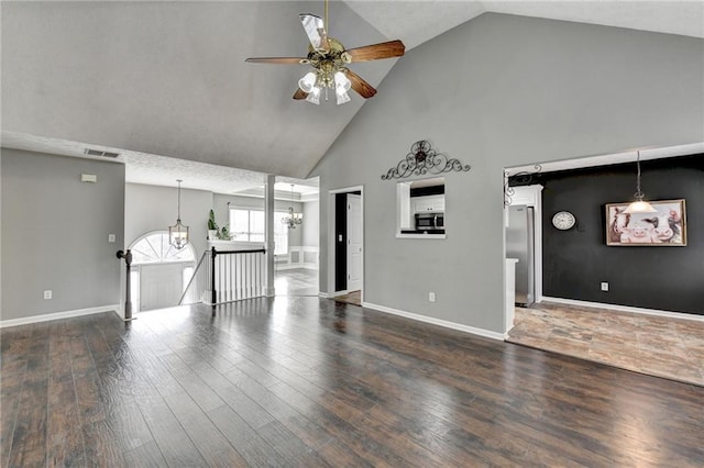 unfurnished living room with baseboards, visible vents, and wood finished floors