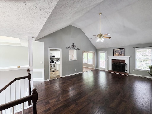 4184 Wyndham Park Way, Buford, GA 30519 - unfurnished living room with wood-type flooring, ceiling fan, plenty of natural light, high vaulted ceiling, and a fireplace