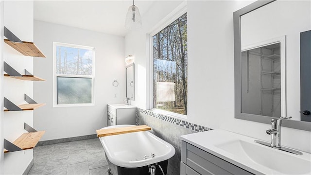 bathroom featuring tile walls, plenty of natural light, vanity, and a bath