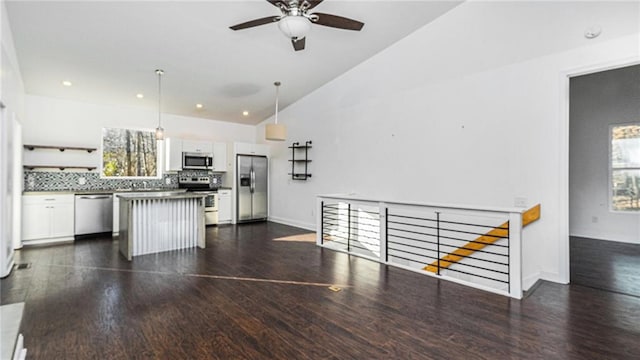 kitchen featuring white cabinetry, a center island, dark hardwood / wood-style flooring, decorative light fixtures, and appliances with stainless steel finishes