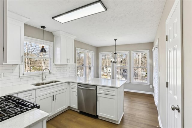 kitchen featuring dishwasher, sink, kitchen peninsula, and white cabinets