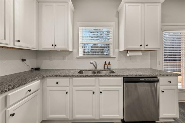 kitchen with plenty of natural light, sink, stainless steel dishwasher, stone countertops, and white cabinetry