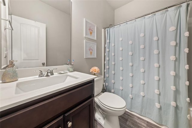 bathroom with curtained shower, hardwood / wood-style floors, vanity, and toilet