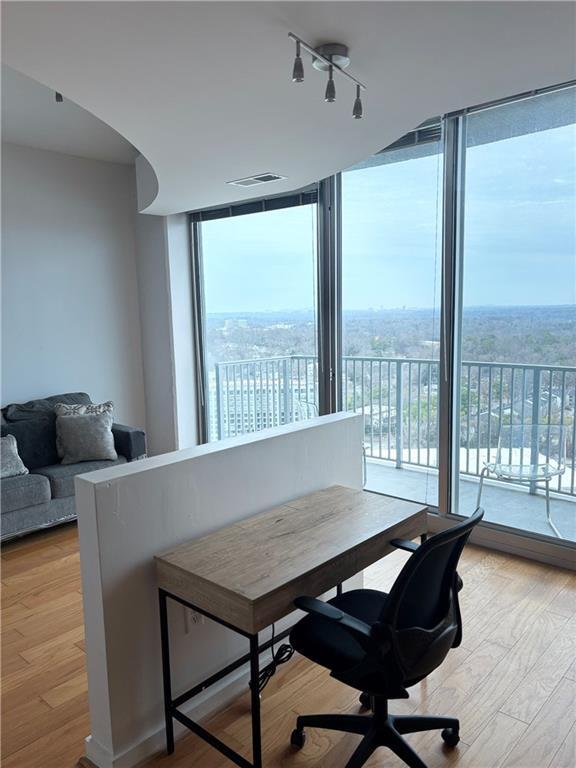 office space featuring plenty of natural light, light hardwood / wood-style floors, and floor to ceiling windows