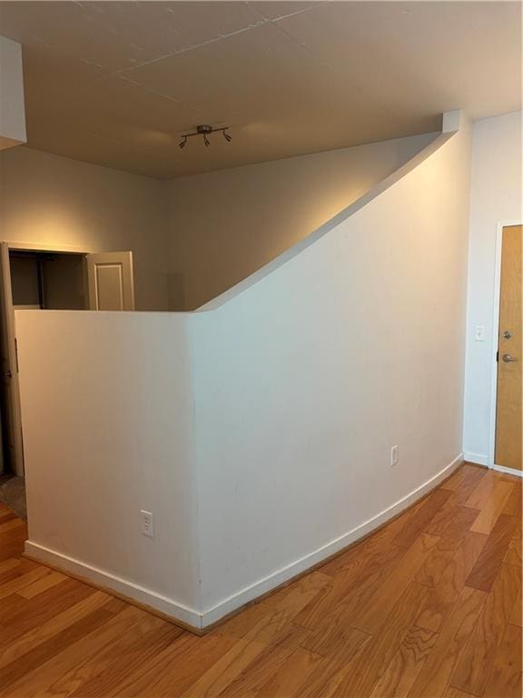 hall with light hardwood / wood-style floors and rail lighting