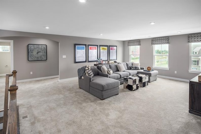 living area featuring recessed lighting, baseboards, and light colored carpet