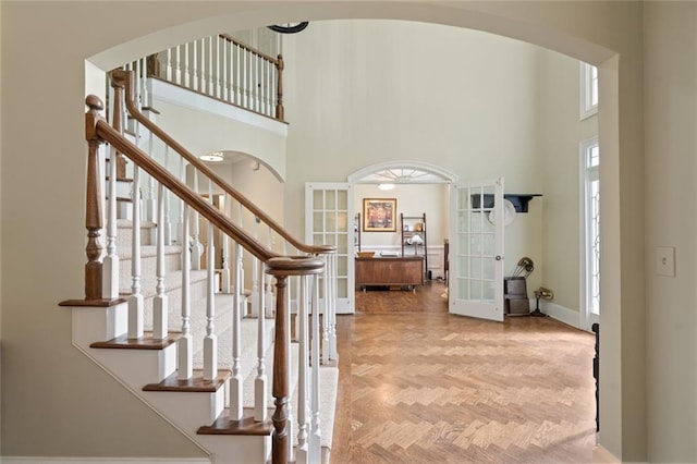 4575 Dairy Way, Peachtree Corners, GA 30092 - foyer entrance with french doors, a high ceiling, stairs, baseboards, and arched walkways