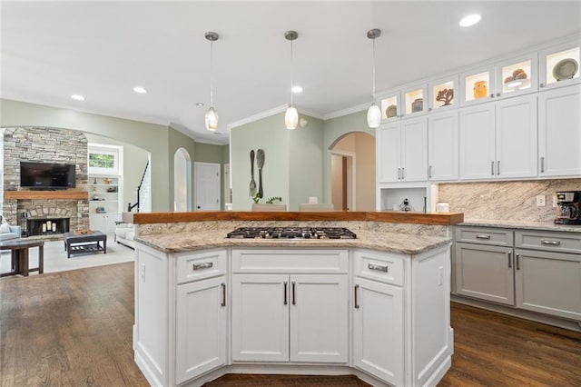 4575 Dairy Way, Peachtree Corners, GA 30092 - kitchen featuring stainless steel gas cooktop, dark wood finished floors, crown molding, arched walkways, and hanging light fixtures