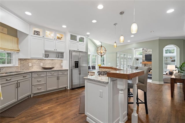 4575 Dairy Way, Peachtree Corners, GA 30092 - kitchen featuring appliances with stainless steel finishes, open floor plan, arched walkways, tasteful backsplash, and a kitchen bar