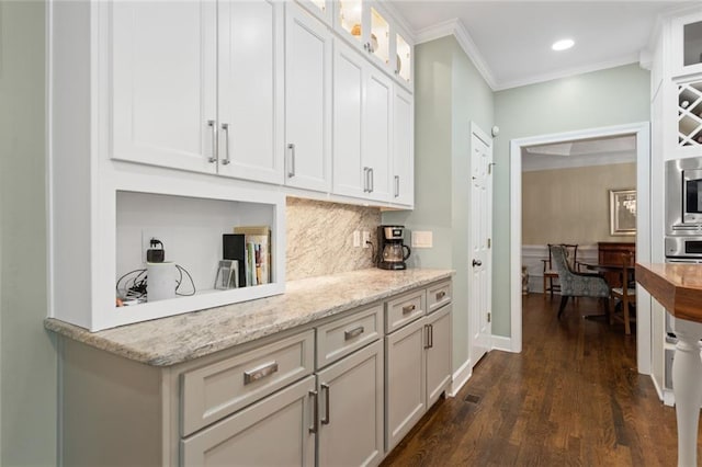 4575 Dairy Way, Peachtree Corners, GA 30092 - kitchen featuring decorative backsplash, crown molding, dark wood-style floors, glass insert cabinets, and light stone counters