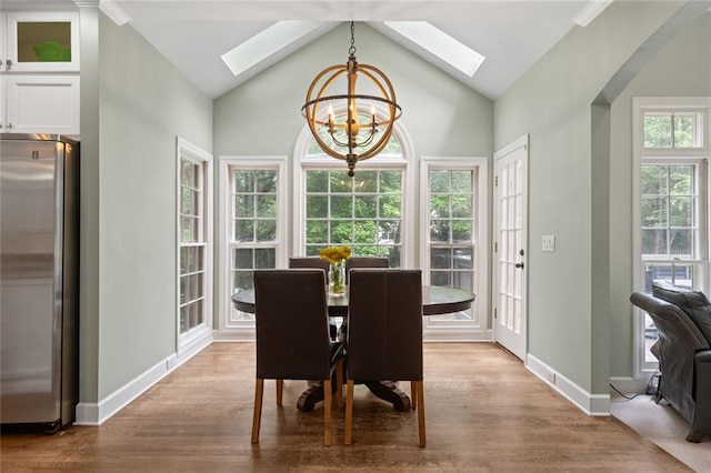 4575 Dairy Way, Peachtree Corners, GA 30092 - dining space with a skylight, a chandelier, wood finished floors, vaulted ceiling, and baseboards