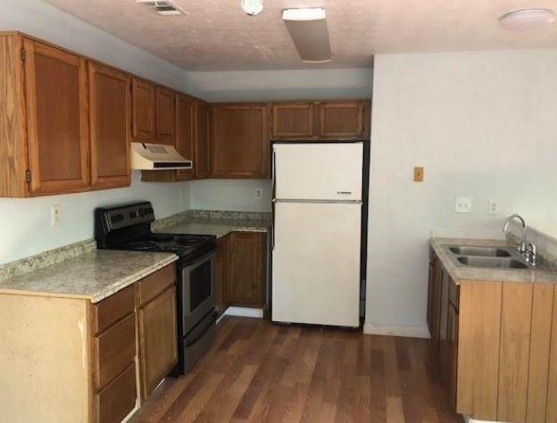 kitchen with black range with electric cooktop, sink, dark wood-type flooring, and white refrigerator