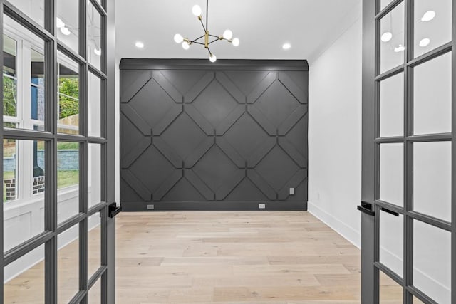 interior space featuring light hardwood / wood-style floors, a healthy amount of sunlight, and a notable chandelier