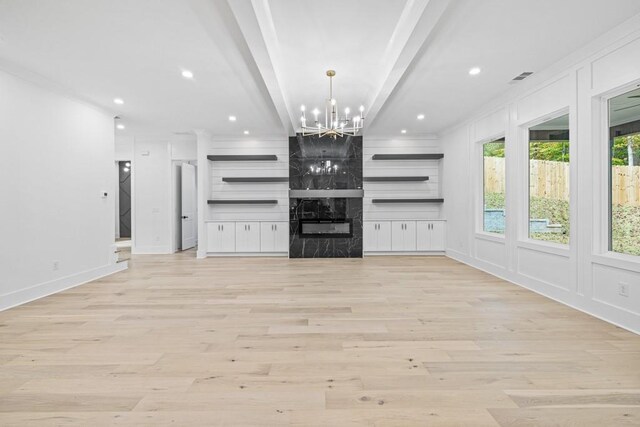 unfurnished living room featuring ornamental molding, light hardwood / wood-style flooring, beam ceiling, and an inviting chandelier