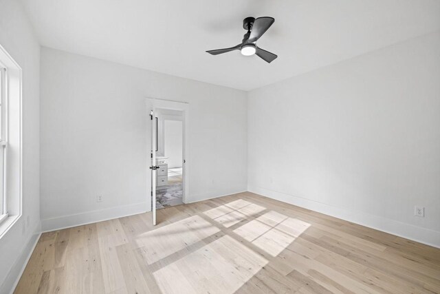 unfurnished room with a healthy amount of sunlight, light wood-type flooring, and ceiling fan