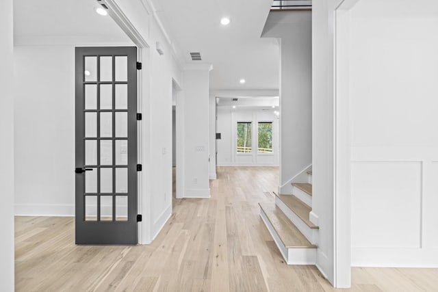 foyer with light hardwood / wood-style flooring and ornamental molding