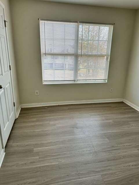 unfurnished bedroom featuring multiple windows and hardwood / wood-style flooring